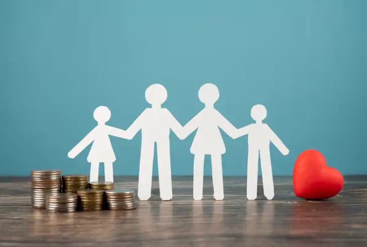 Family holds hands, coins beside heart.